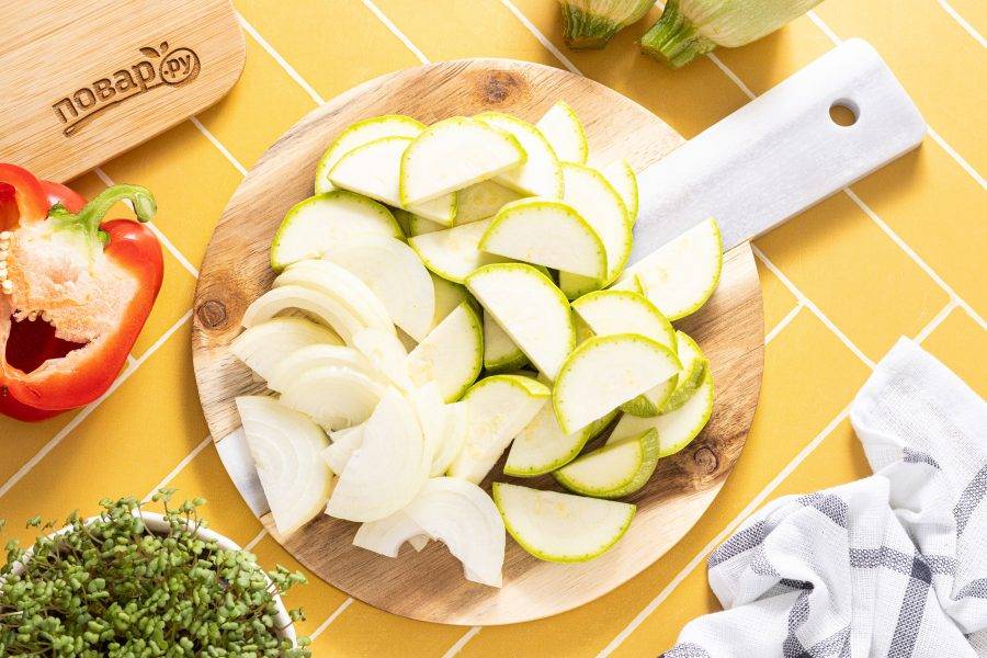 Кабачки нарежьте кружочками или полукружьями, а репчатый лук нарежьте полукольцами.