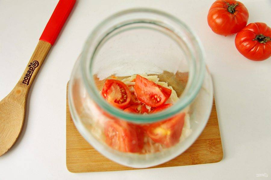 В банку слоями выложите капусту, чередуя ее с нарезанными помидорами.