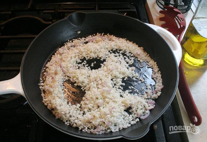 Всыпьте рис. Обжарьте его, хорошо размешивая, 2 минуты. Рис должен напитаться ароматным маслом.
