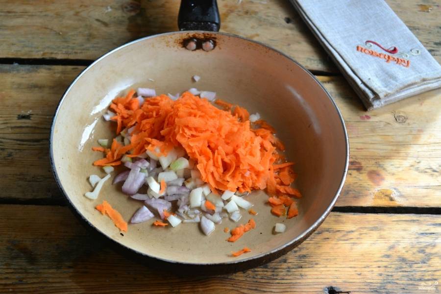 Третью часть лука оставьте для томатной заправки, а остальное обжарьте вместе с морковью в подсолнечном масле до мягкости.