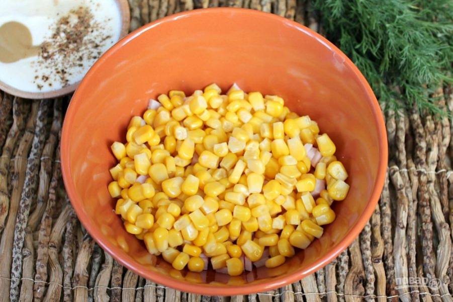 Сливаем жидкость из консервированной кукурузы. Добавляем кукурузу в салат. 