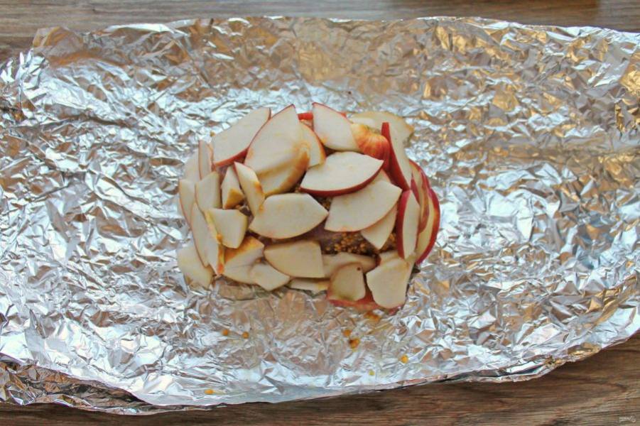 Яблоко разрежьте на четыре части, удалите сердцевину и порежьте на дольки. Через двенадцать часов достаньте карбонат и обложите сверху и с боков яблоком. Заверните тщательно в фольгу.