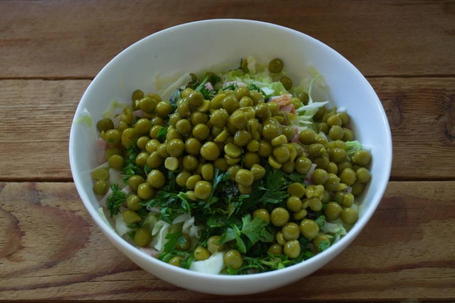 Добавьте зеленый горошек консервированный, оливки. Заправьте салат сметаной. Откорректируйте вкус специями.