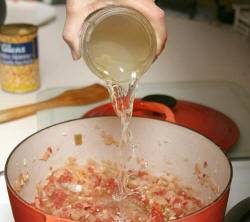 Теперь добавьте куриный бульон и соль. Оставьте на слабом огне еще на 30 минут. После этого суп готов.