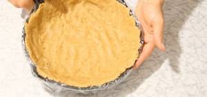 Утрамбовываем печенье с маслом в форму для чизкейка, делая небольшие бортики. Предварительно можно простелить бумагу для выпечки.