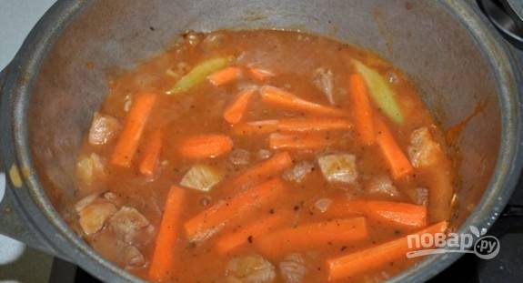 В отдельной посуде смешайте воду с томатной пастой, сахаром и мукой. Соус влейте к продуктам. Добавьте морковь.