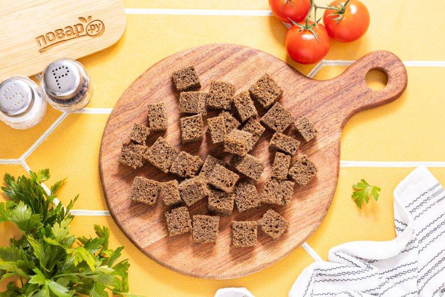 Хлеб нарежьте кубиками размером среднего размера. Подсушите их в духовке до румяного цвета.