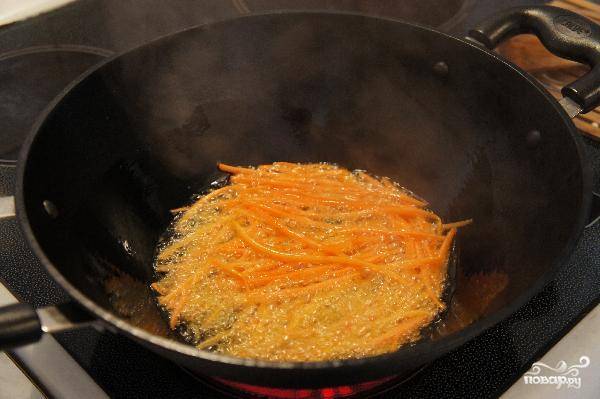 Берем вок, разогреваем в нем растительное масло, затем кладем морковь и быстро обжариваем 3 минуты.