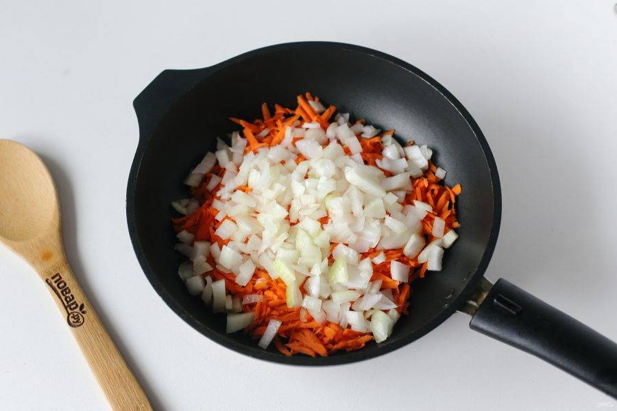 Разогрейте сковороду с маслом. Выложите тертую морковь и нарезанный кубиками лук.