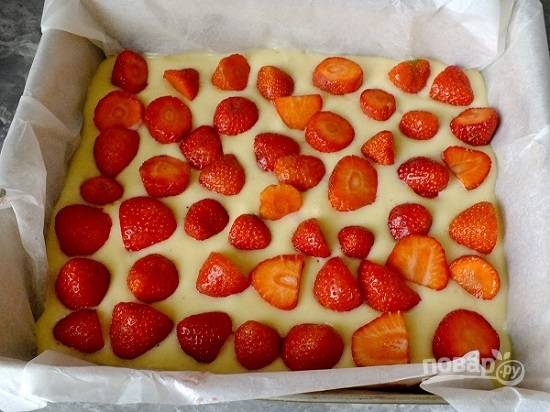 Форму можно просто смазать маслом и посыпать мукой, а можно застелить бумагой для выпечки. Выливаем тесто в форму и сверху выкладываем любые ягоды, затем чуть вдавим их в тесто.