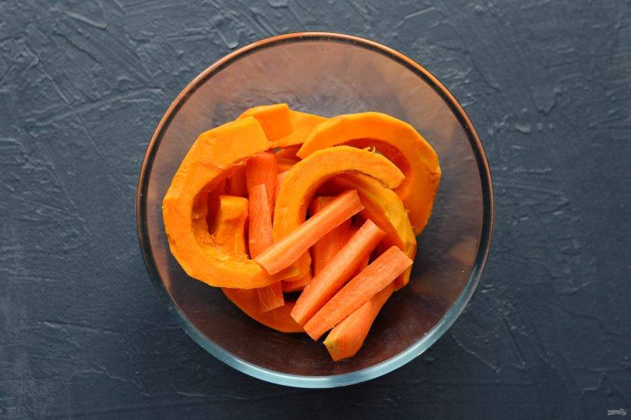 Тыкву очистите от кожуры и нарежьте дольками. Морковь хорошо помойте, нарежьте вдоль на четвертинки. 