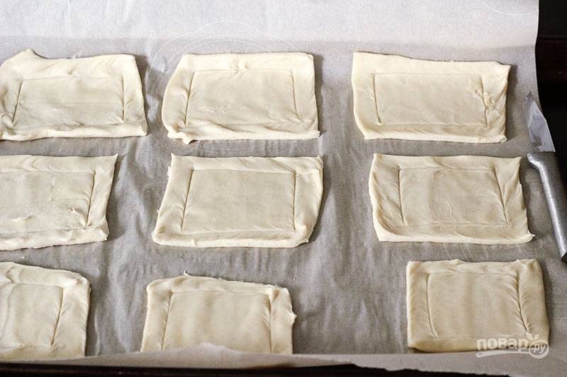 2. Нарежьте тесто квадратами (можно очертить ножом один квадрат внутри, чуть отступив от края) и выложите на противень, застеленный пергаментом. Отправьте в духовку и запекайте до румяности около 15 минут. 