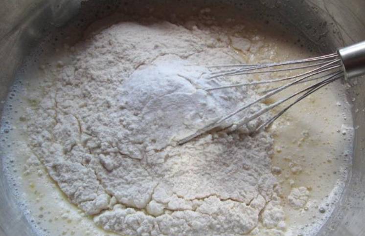 В миску вбиваем яйца, добавляем соль и сахар. Тщательно все взбиваем и вливаем теплое молоко, а затем засыпаем ржаную и пшеничную муку, а также соду.