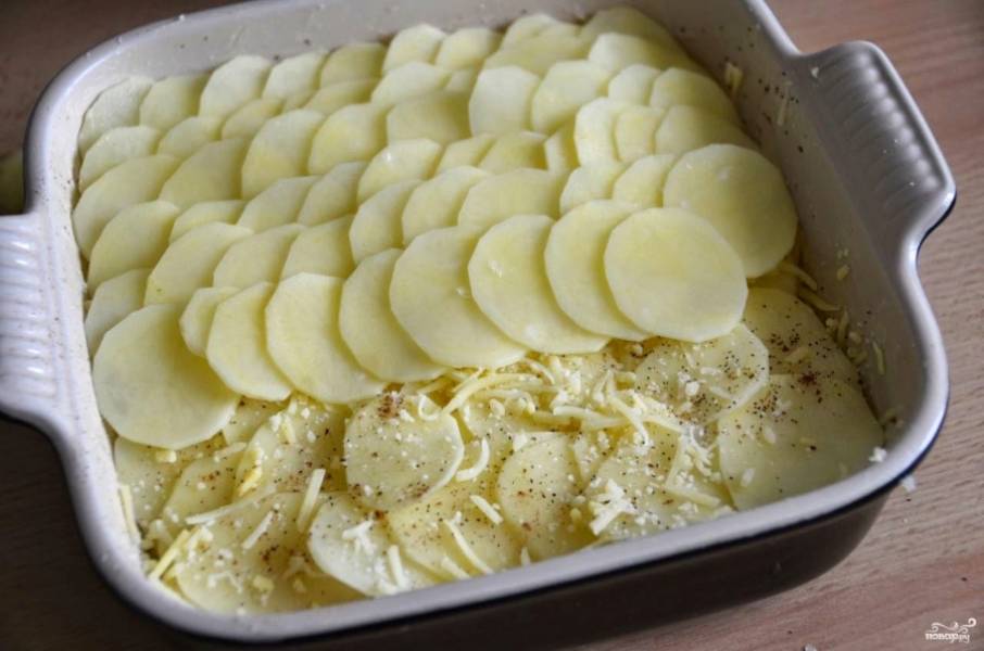 2. А теперь начинаем выкладывать слоями: слой картошки чередуйте со слоем тертого сыра, сметаны и специй. И так, пока картошка не закончится. 