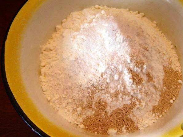 Приготовление пирога начнем с теста. Смешайте муку, соль и сухие дрожжи. Нагрейте воду, смешайте её с молоком и растительным маслом. Влейте смесь в муку и замесите тесто. Оставьте его под полотенцем на 50 минут в теплом месте. Затем обомните его и дайте подняться еще полчаса. 
