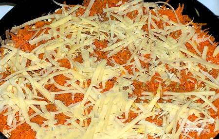 Морковку чистим, моем и натираем мелко. Кладем сверху, на картофельный слой. Посыпаем специями и тертым сыром.