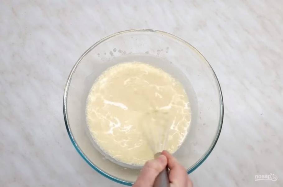 2.  Кислое молоко подсолите, добавьте желтки, перемешайте венчиком и добавьте соду. Далее добавьте просеянную через сито муку. Тесто должно получиться довольно густым. 