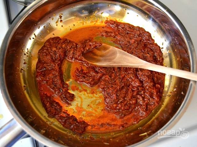 2.	Добавьте в сковороду к ароматным травам томатную пасту, перемешайте и тушите на слабом огне несколько минут.