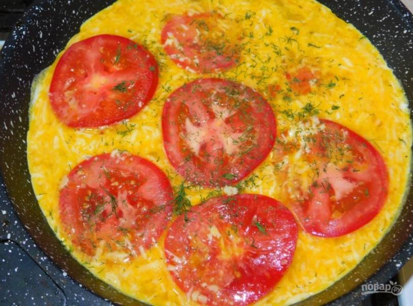 Залейте сырной смесью сухарики. Выложите помидоры, нарезанные кружками. Немного посыпьте зеленью. Накройте крышкой и готовьте на маленьком огне до готовности (минут 7-10)