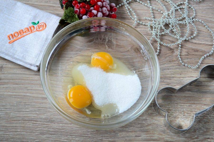 В глубокую миску разбейте 1 яйцо, а второе разделите на белок и желток, желток отправьте к предыдущему яйцу в миску, а белок - в сухой и чистый стакан для взбивания (он нам понадобится для приготовления глазури). Но пока работаем с тестом, к яйцам отправьте сахар и щепотку соли и взбейте миксером, чтобы сахар растворился, а масса увеличилась в объеме. 