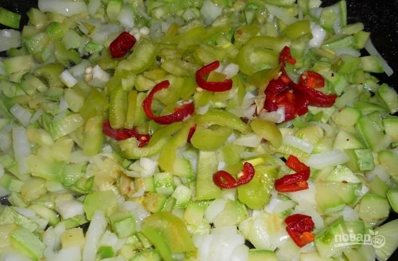 Далее добавьте в сковороду нашинкованный средними кусочками перец. Жарьте овощи 4 минуты.