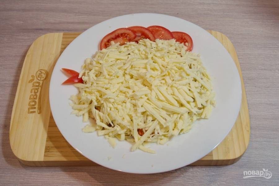 7. Из небольшого кусочка помидора сделайте клювик. Натрите на крупной терке сыр. Закройте весь салат тертым сыром.