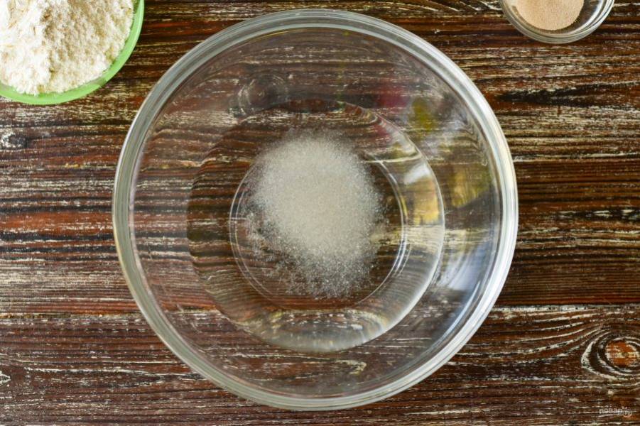 В миску влейте теплую воду, добавьте соль и сахар, перемешайте.