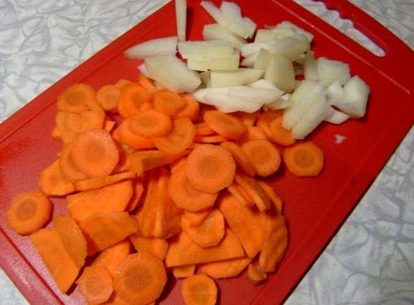 Пока курица маринуется, мы чистим овощи и нарезаем морковь кружочками, а репчатый лук небольшими кубиками. 