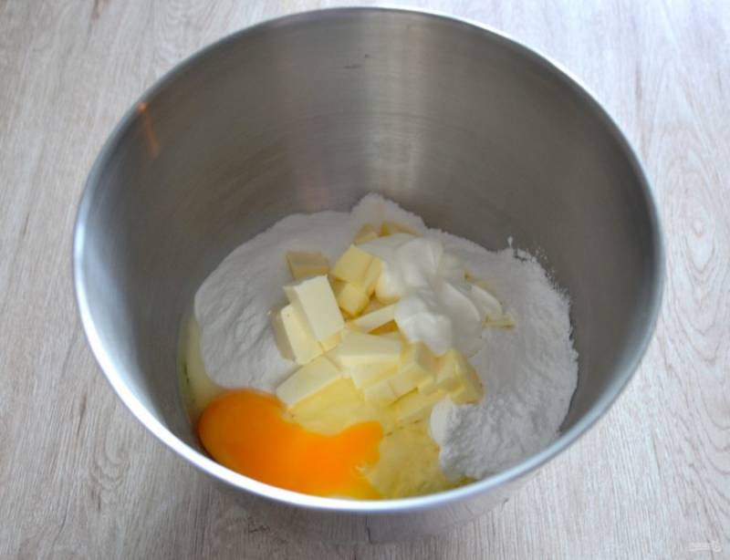 Добавьте в мучную смесь сливочное масло, нарезанное кубиком, вбейте 1 яйцо, добавьте сметану. Руками или с помощью миксера перетрите все в крошку.
