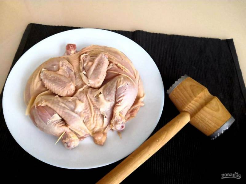 Курицу разрезать пополам, расплющить и отбить.