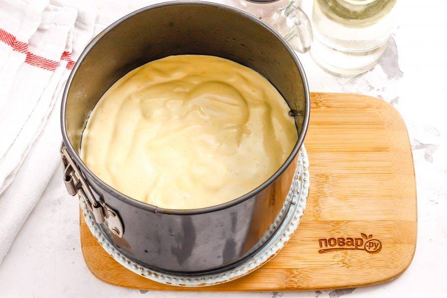 Смажьте форму растительным или сливочным маслом, вылейте в нее бисквитное тесто — оно будет густым, но не плотным.