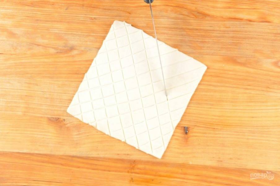 3. Разморозьте тесто и нарежьте сеткой в виде квадратиков, затем разделите пополам.