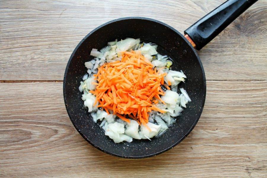 Пока варится курочка, приготовьте зажарку. Для этого в сковороде разогрейте на среднем огне растительное масло и выложите мелко порезанный лук и натертую на крупной терке морковь. Обжаривайте все в течение 7 минут, перемешивая.