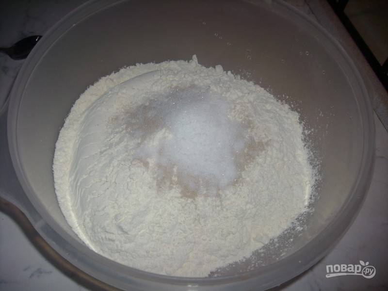 1.	Просейте в миску муку, добавьте сухие дрожжи, 2 чайные ложки сахара, соль и перемешайте.