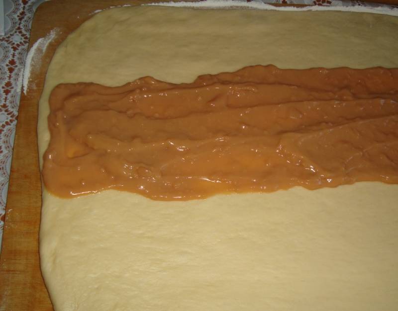 Раскатайте готовое тесто в пласт, выложите на его середину пудинг. 