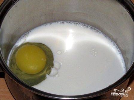 Масло для крема должно быть комнатной температуры, поэтому заранее достаньте его из холодильника. Наливаем молоко в небольшую кастрюлю и добавляем к нему яйцо, взбиваем миксером.