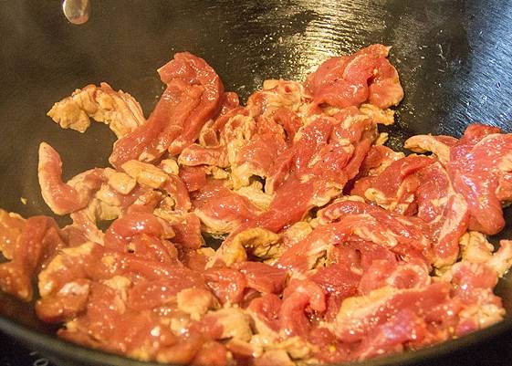 В вок или на обычную сковородку добавляем две ложки масла и обжариваем чеснок. Затем достаем его и обжариваем мясо на самом сильном огне, постоянно перемешивая. Мясо, покрывшееся золотистой корочкой, вытаскиваем и перекладываем на тарелочку.