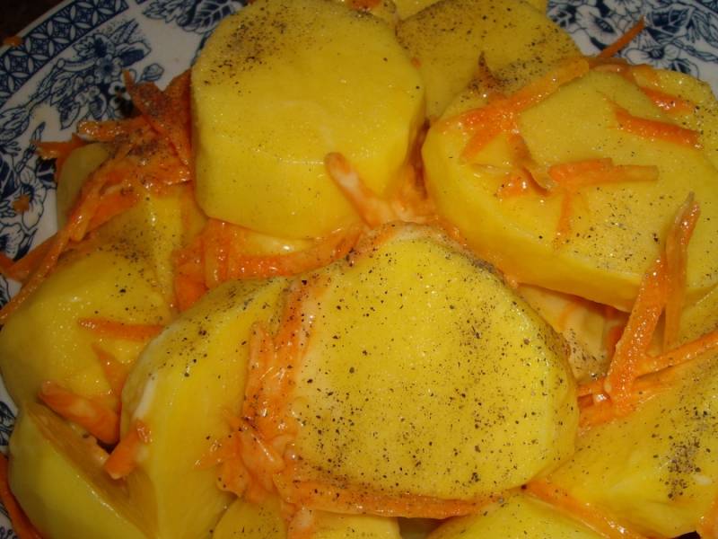 3. Картофель моем, чистим, нарезаем кругляшами, добавим тертую на крупной терке морковь и растительное масло. Солим и перчим.
