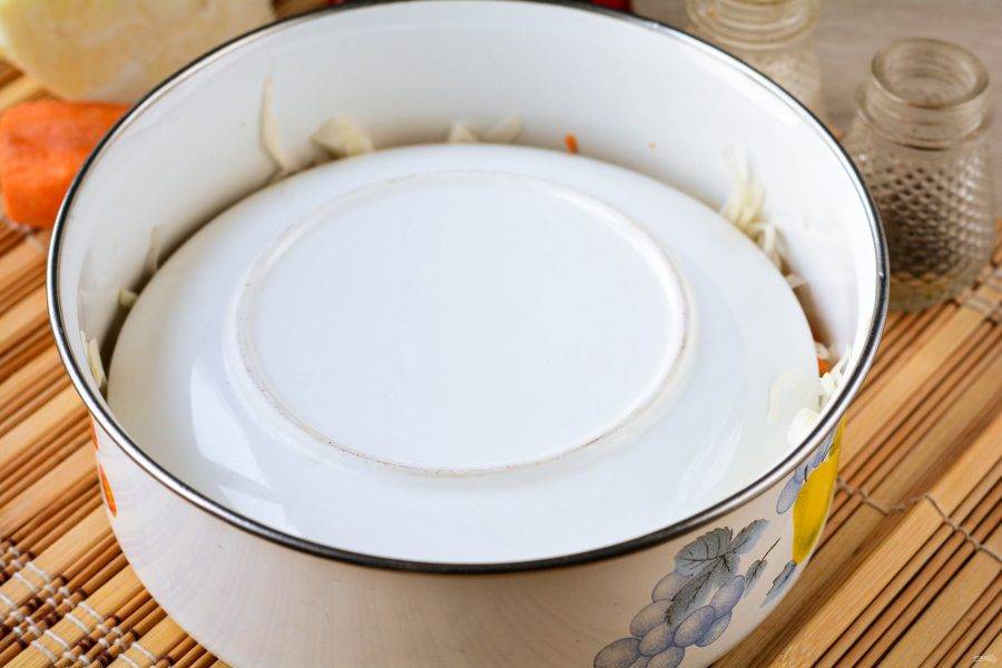 Прикройте капусту тарелкой или крышкой, оставьте сквашиваться на столе на 2-3 дня. Каждый день прокалывайте капусту деревянной ложкой или шпажкой, чтобы она не потемнела.