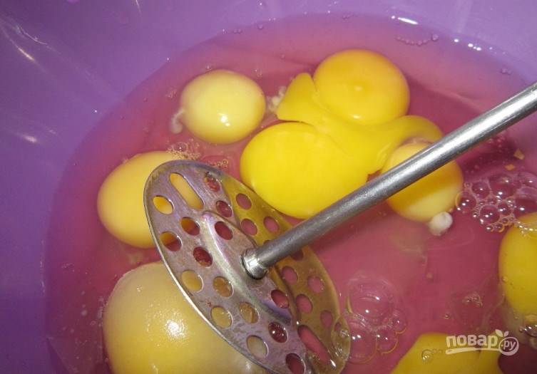 Возьмите миску и вбейте в нее восемь сырых куриных яиц. Добавьте к ним гашенную любой кислотой соду. При помощи толкушки взбивайте яйца до тех пор, пока они не превратятся в однородную массу. 