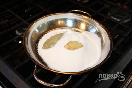 1. Первым делом нужно сделать сироп. На сковороду всыпьте сахар. Для аромата добавьте лавровый лист и корень имбиря. 