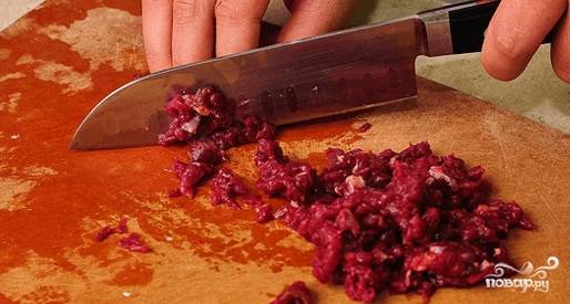 Мясо порежьте острым ножом на довольно мелкие кусочки.
