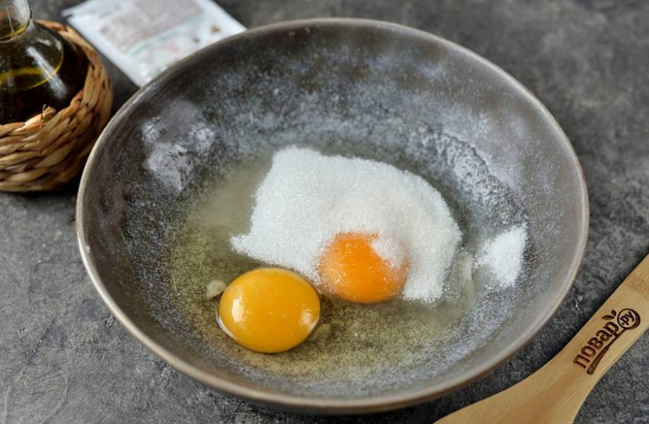 В глубокую миску вбейте два мелких яйца, всыпьте сахар, ванильный сахар и щепотку соли. Взбейте их до однородного состояния. Если яйцо крупное, тогда достаточно 1 штуки, но тогда нужно уменьшить количество муки.