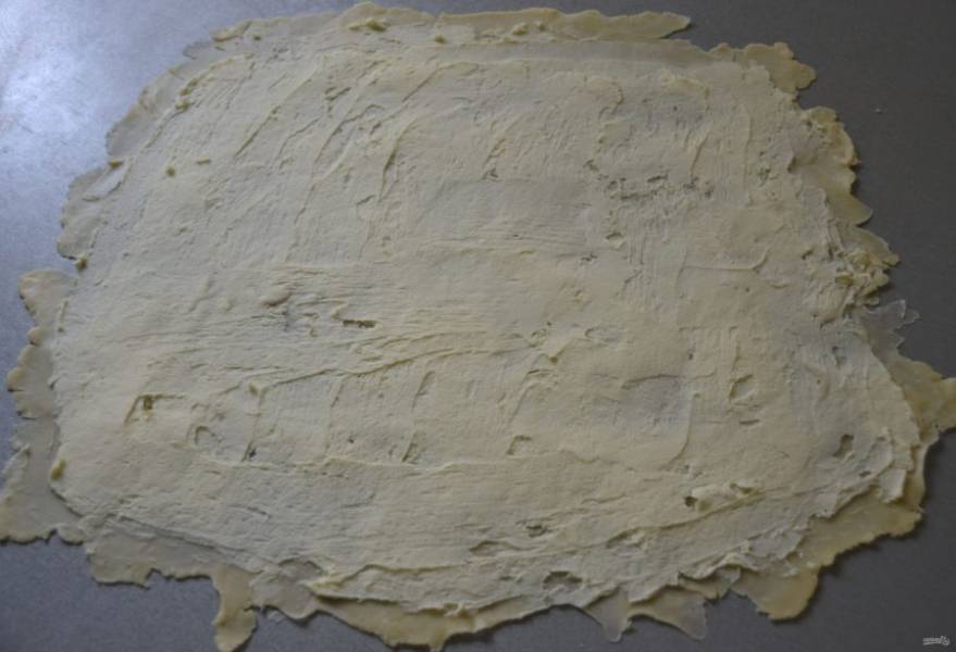 Выложите на тесто масляно-мучную смесь и равномерно разровняйте по всей поверхности теста.
