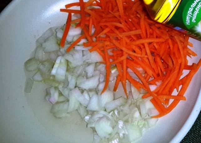 Грибы промойте, залейте горячей водой на 20 минут. Затем снова промойте и порежьте. Измельчите лук и морковь и обжарьте их на растительном масле. 
