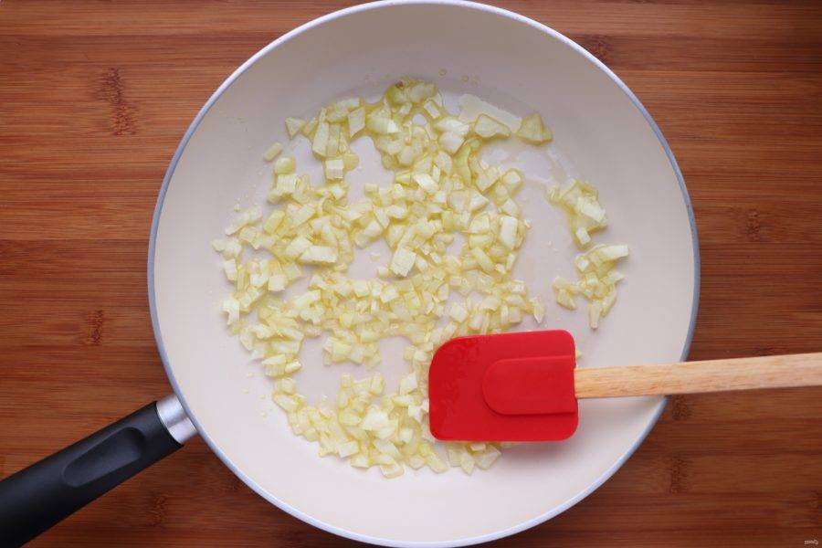 На разогретую сковороду добавьте 3 ст. л. растительного масла и обжарьте нарезанный лук до прозрачности. 