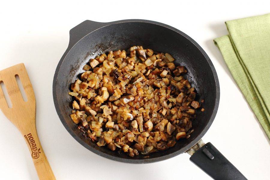 Грибы и лук нарежьте кубиками. Обжарьте на растительном масле до готовности, посолите и поперчите по вкусу.