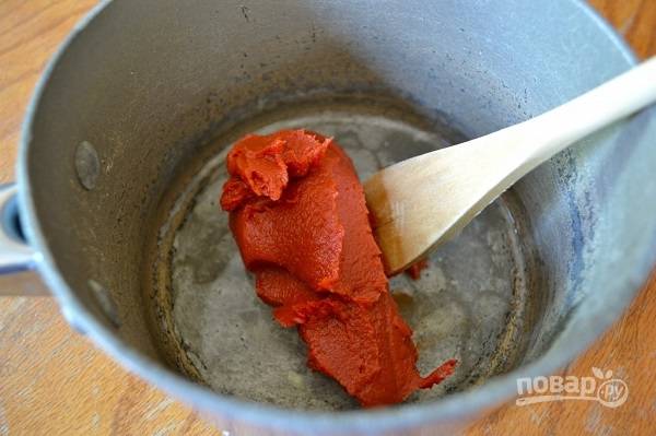 1. Сам процесс приготовления действительно очень простой и весьма быстрый. Итак, выложите томатную пасту в сотейник, добавьте воду, поставьте на огонь. 