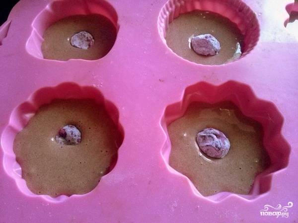 Разогрейте духовку до 180С.
Силиконовые формы для кексов смочите водой. Наполните формочки тестом на 2/3, опустите в каждую по вишенке. Можно добавлять от одной до трех ягод.
Выпекайте кексы 25-30 минут до сухой шпажки.
