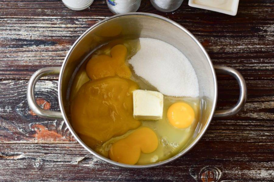 В кастрюлю вбейте куриные яйца, всыпьте сахар и соль, выложите мед и сливочное масло.